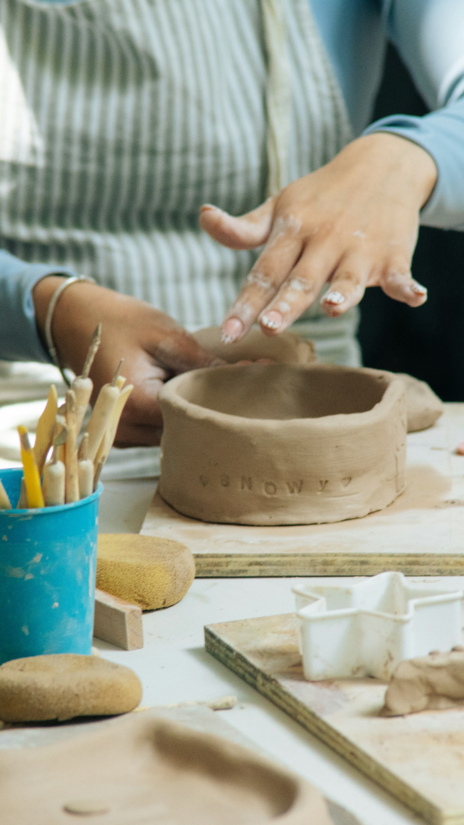 Dłonie formujące glinę na warsztatach ceramicznych